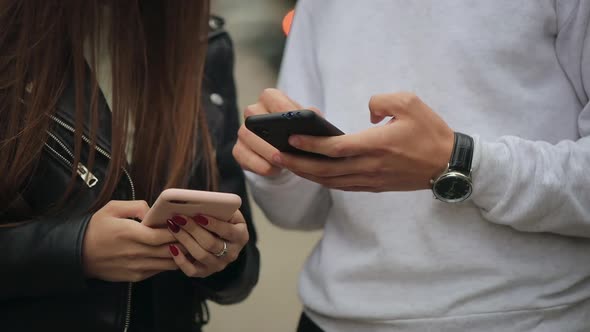 A Young Woman and a Man are Exchanging Information on Smartphones