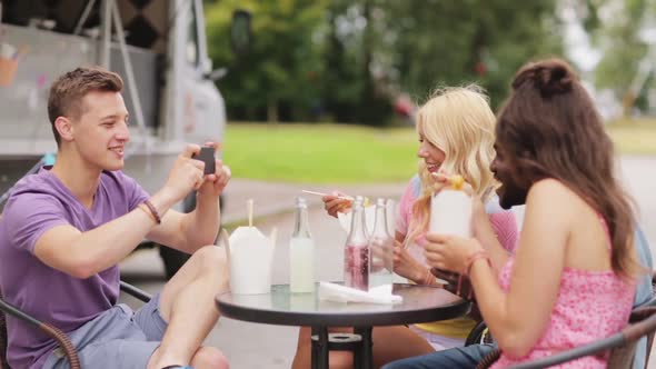 Man Taking Video of Friends Eating at Food Truck 