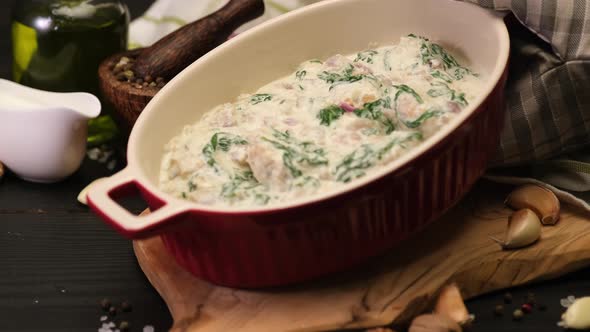 Delicious Small Meatballs with Spinach in a Creamy Sauce in Baking Dish