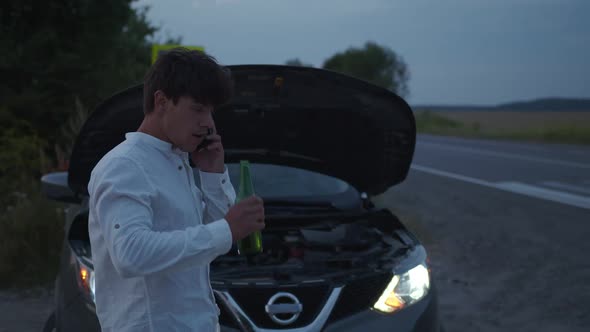 Drunk Man Stands Near His Broken Car on Road