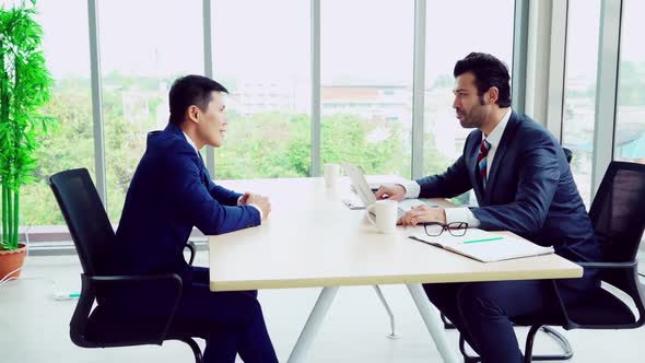 Two Business People Talk Project Strategy at Office