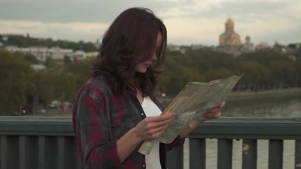 Young Woman with Tourist Map Looking Around in the City Street