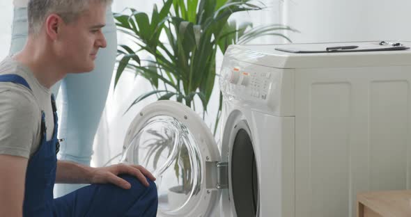 Technician fixing a broken washing machine