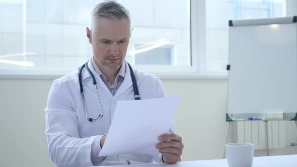 Doctor Reading Medical Papers in Clinic