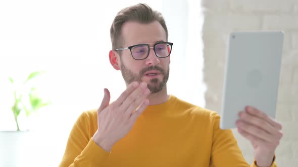 Portrait of Video Call on Tablet By Man in Office