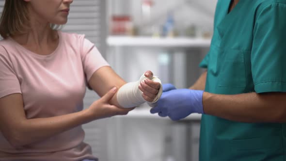 Surgeon Applying Elastic Wrap on Female Patient Arm, Rehabilitation After Trauma
