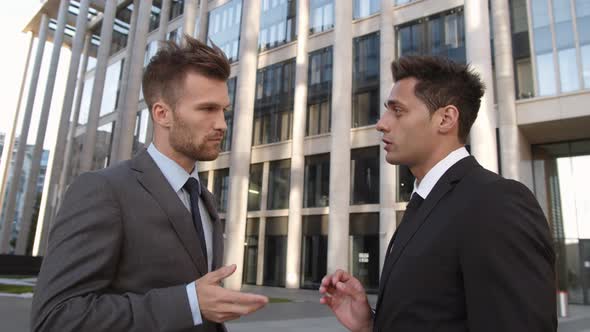 Two Handsome Businessmen Communicating on Street