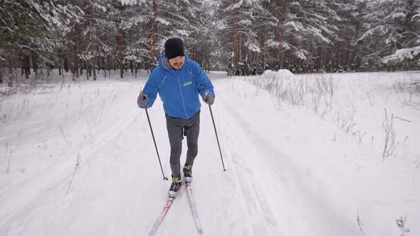 A Young Man Is Engaged in Crosscountry Skiing in the Winter Forest