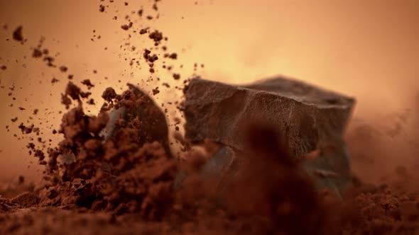 Super Slow Motion Shot of Raw Chocolate Chunks Falling Into Cocoa Powder at 1000Fps.