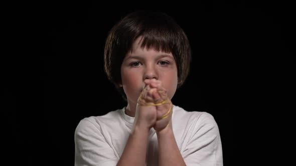 Portrait of Beaten Boy Showing Roped Hands Looking at Camera