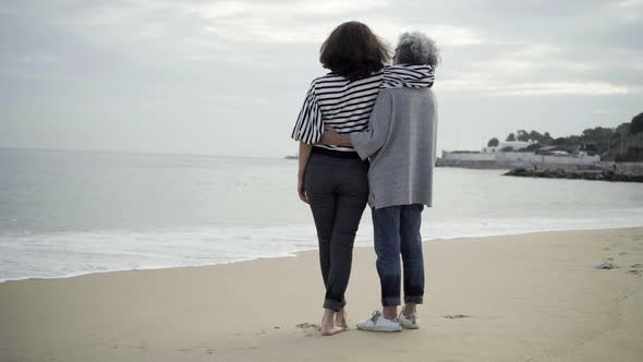 Happy Daughter and Mother Standing at Seashore, Talking