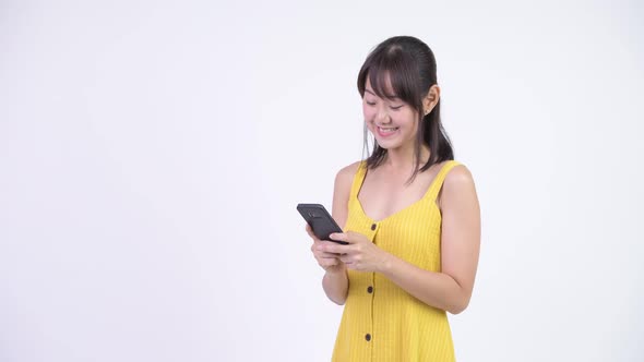 Happy Beautiful Asian Woman Smiling While Using Phone