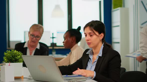 Concentrated Manager Typing on Laptop Sitting at Desk in Start Up Business