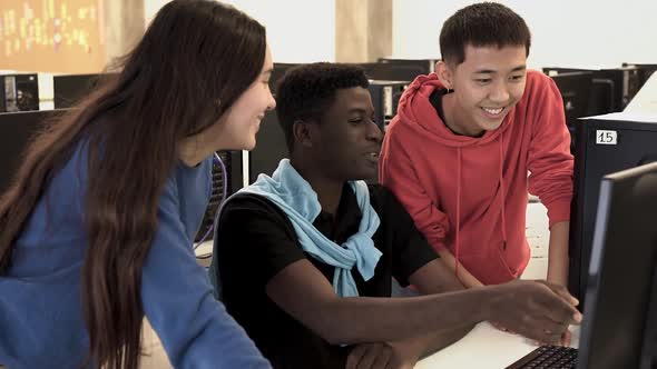 Young diverse students learning together inside computer class room