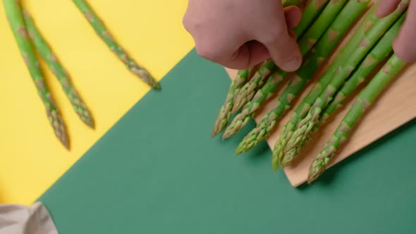 Vertical Flat Lay Video the Cook Cuts Raw Asparagus on the Wooden Board