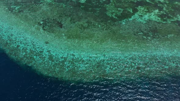 Aerial: Flying over tropical beach turquoise water coral reef, Indonesia 