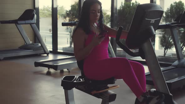 A Young Active Sportswoman a Young Brunette is Engaged in the Gym Doing Exercises on an Exercise