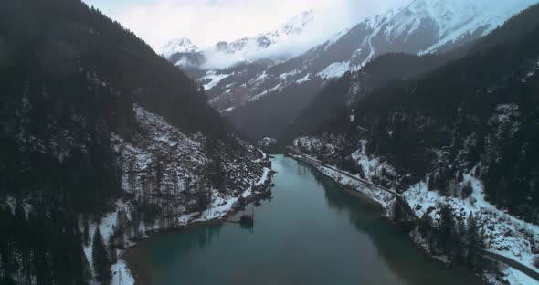 mountain lake with blue water in alps during heavy snow with mountains on background