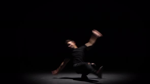 Silhouette of a Talented Young Break Dancer. Hip Hop Street Dance on a Stage in Back of the