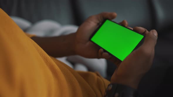 Close Up Smartphone with Green Screen in the Hands of Unrecognizable African American Black Man