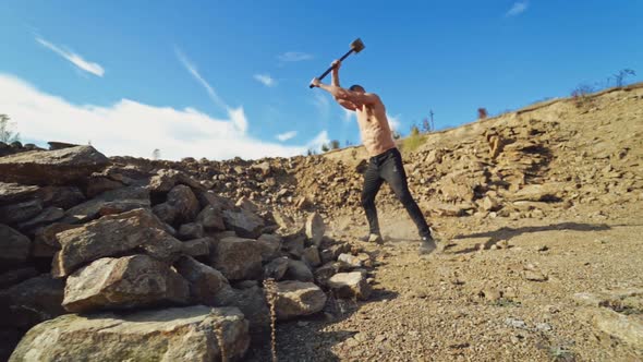 Shirtless sportsman with huge hammer outdoors