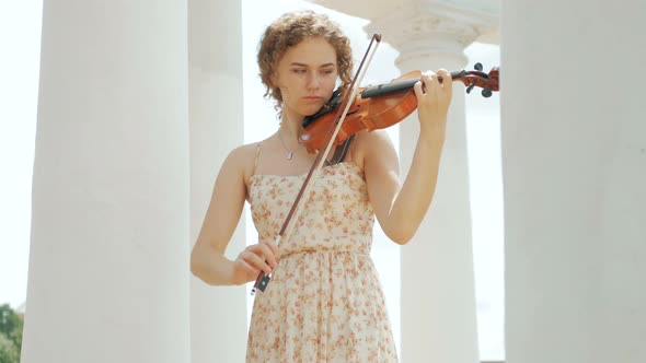 young curly blond woman the violinist: Musician playing violin