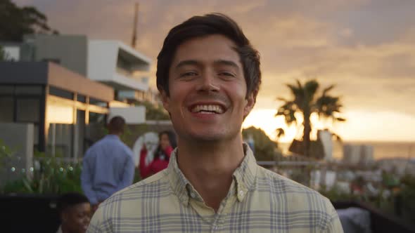 Young man smiling at camera on a rooftop