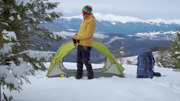 Traveler Near a Tent in the Mountains