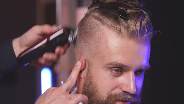 Male Hairstylist Trimming Hair To Customer with Electric Razor