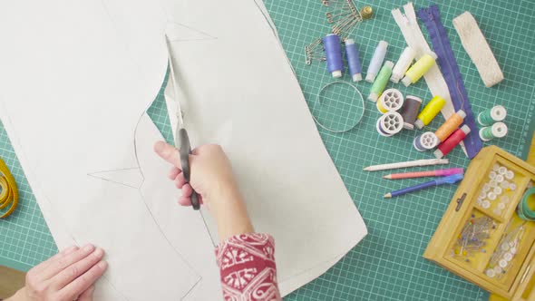 Woman hands cutting paper template