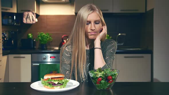 Young Woman Choosing Between Hamburger and Salad.