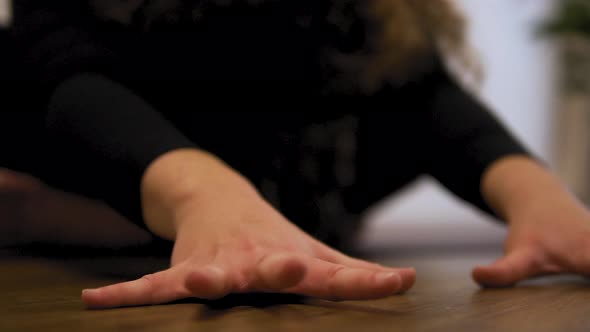 Female yoga instructor is doing gymnastic. Closeup of hands doing yoga, meditation and stretch in th