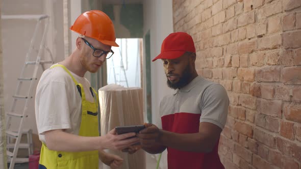 Foreman Receiving Delivery From Courier at Construction Cite and Signing Document on Tablet