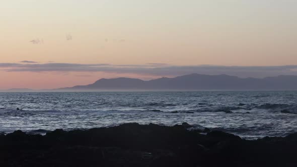 The early morning sunrise glow over the ocean towards wilson prom country mountains in Australia.
