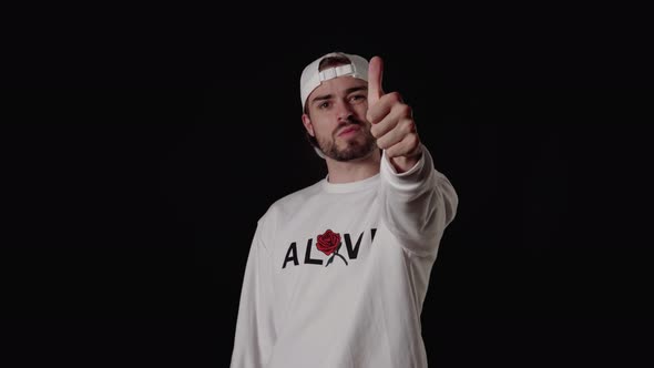 Trendy 20s Man giving thumbs up, appreciative gesture, wide, black background