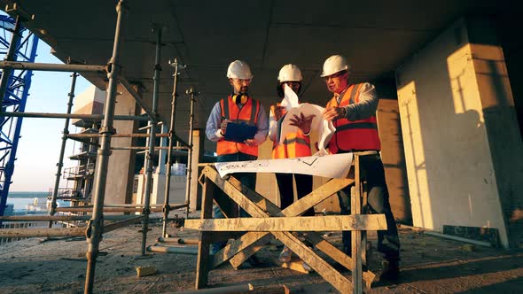 Building in Progress with Engineers Discussing Layouts in It alt