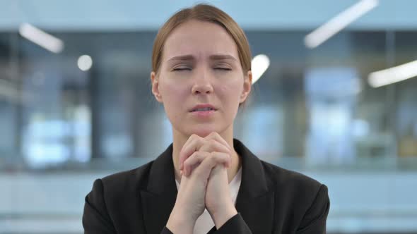 Portrait of Businesswoman Praying with Eyes Closed