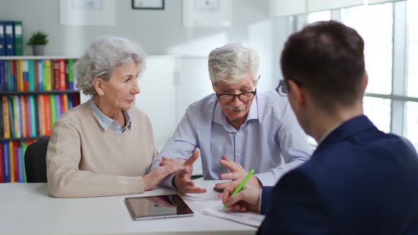 Senior Man and Woman Having Meeting with Financial Adviser