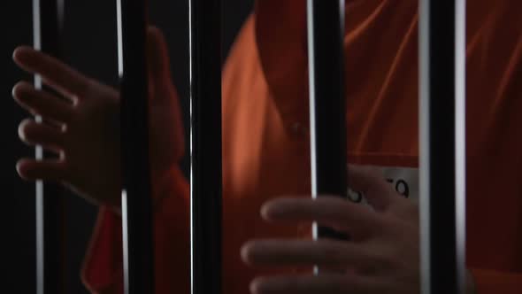 Hands of Angry Arrested Male Gripping Prison Bars, Unfair Judgment, Closeup