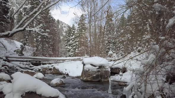 Panning over river flowing through winter landscape