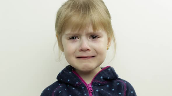 Portrait of Little Child Girl Crying with Tears Down Her Face. White Background