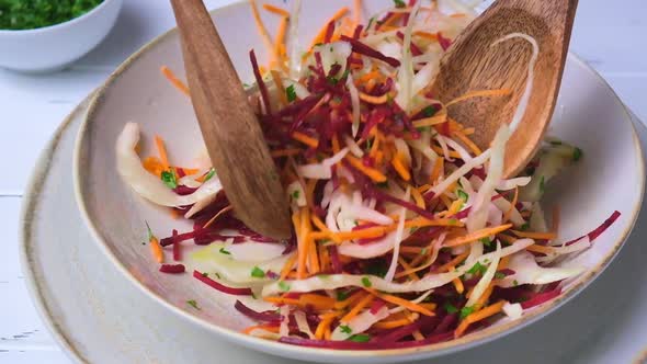 Beetroot, carrot, cabbage salad with oil and herbs, gray background.