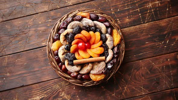 Mix of Dried Fruits in a Small Wicker Basket on Wooden Table