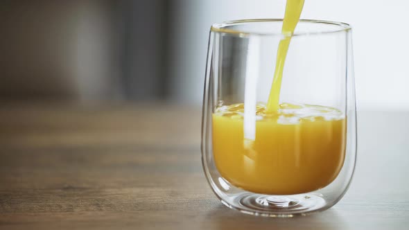 orange juice is pouring into a glass. simple nutritious breakfast. quench your thirst with a refresh