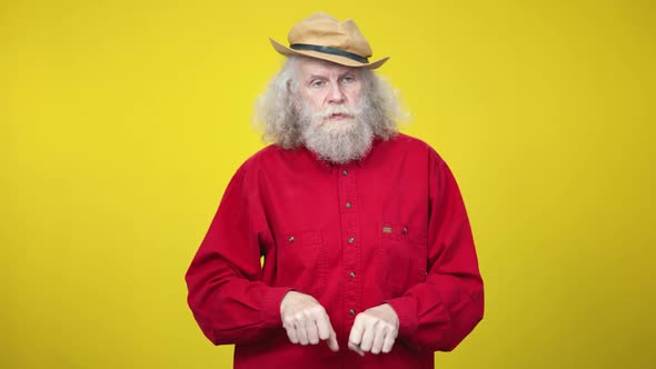 Serious Senior Caucasian Man Imitating Horse Riding at Yellow Background