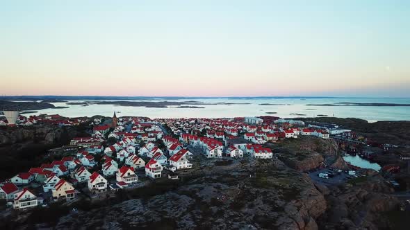 Drone flying close to a small beautiful village next to the coastline in Sweden.