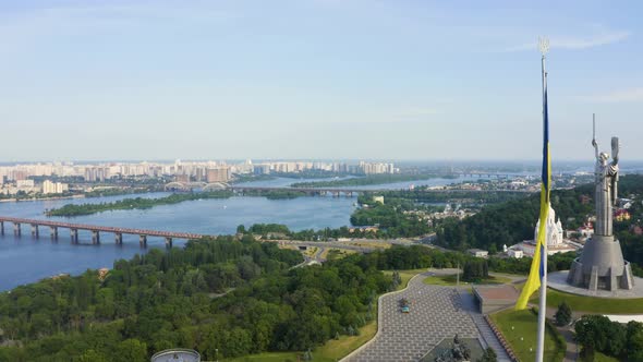 Aerial View of the Ukrainian Flag Waving in the Wind Against the City of Kyiv