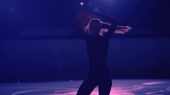 Young Female Figure Skater is Performing Single Skating Choreography on Ice Rink Against Background