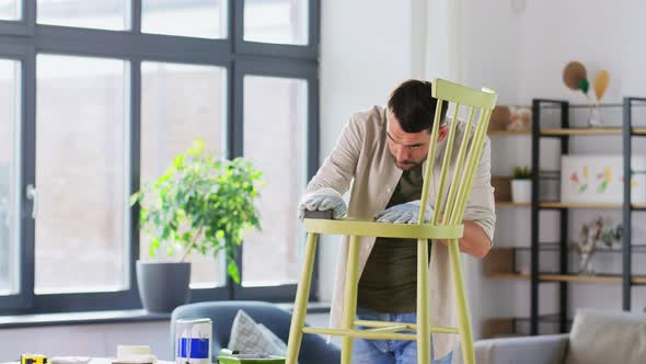Man with Sponge Sanding Old Wooden Chair at Home