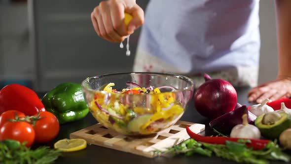 Housewife Squeezing Lemon To a Vegetable Salad